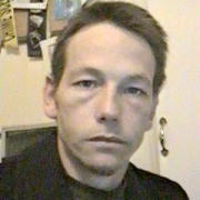 Shawn Sharpe Unsmiling man with short dark hair
